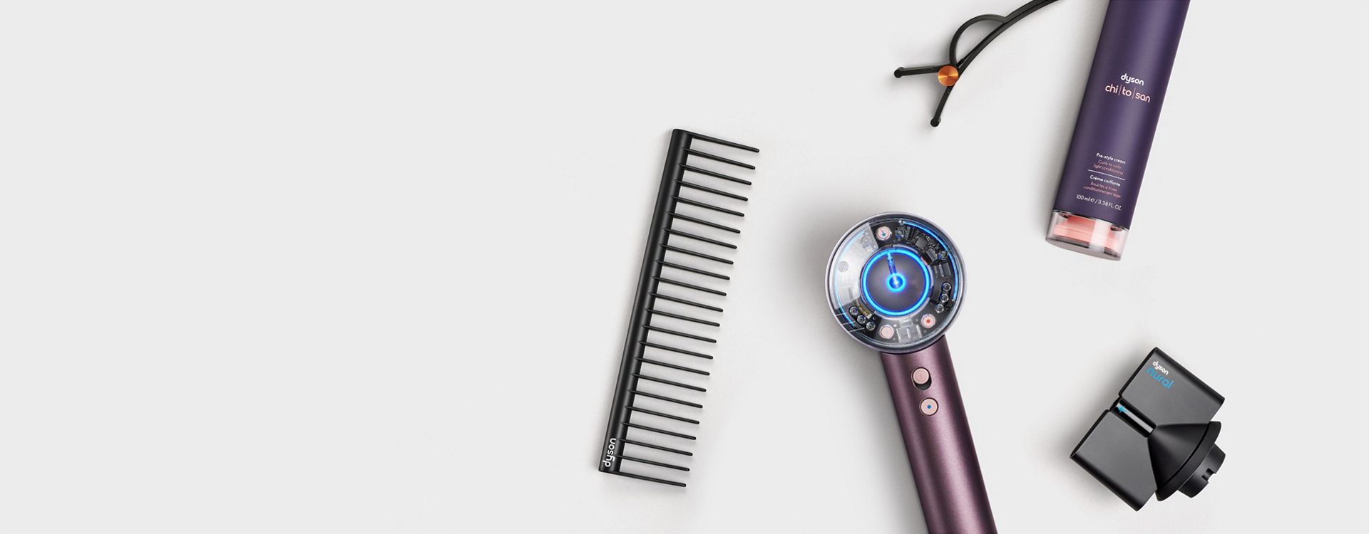 The Dyson Supersonic Nural hair dryer in Jasper plum surrounded by attachments and accessories.
