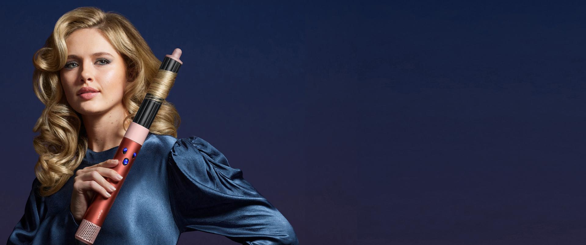 A woman uses the Dyson Airwrap.