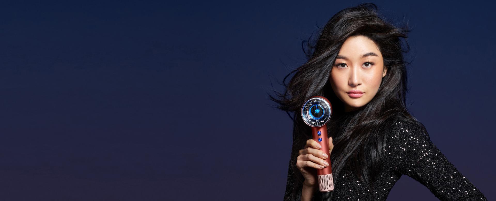 A woman uses the Dyson Supersonic Nural.