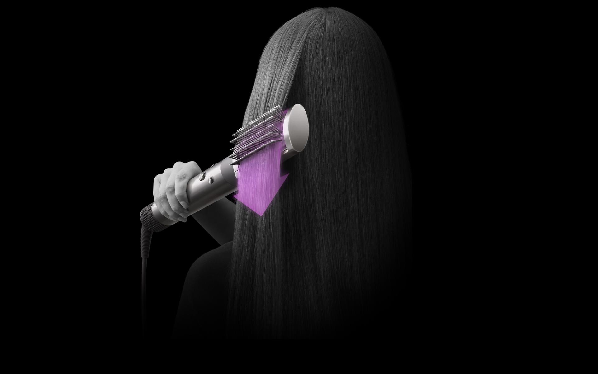 The Airwrap multi-styler and dryer being used with its brush attachment to shape hair