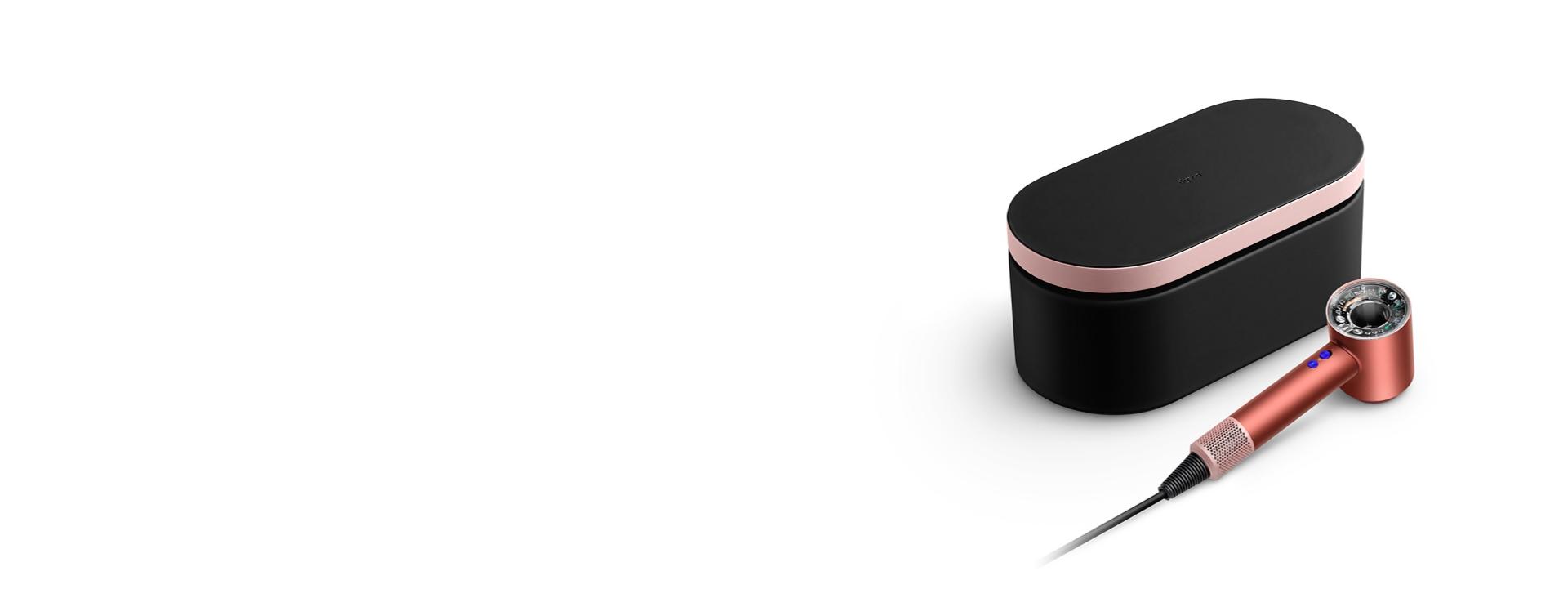 The Dyson Supersonic hair dryer beside its attachments and presentation case