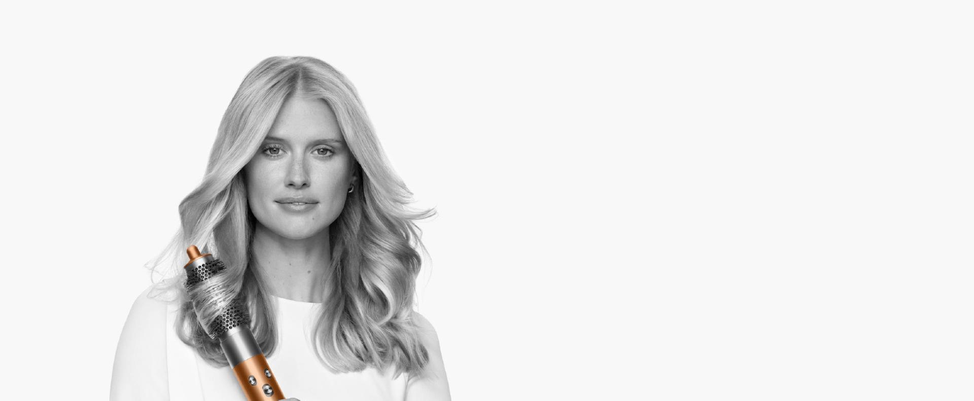 سيدة شعرها من النوع الثاني تَستخدم مصفف الشعر Dyson Airwrap متعدد الوظائف