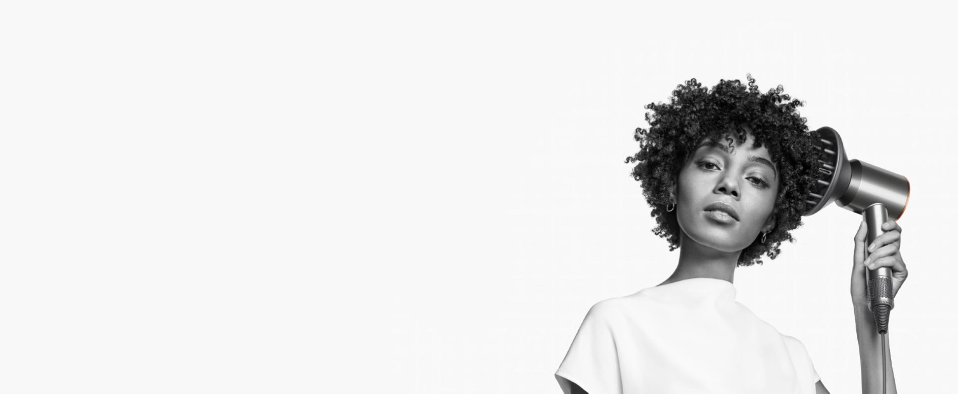 Woman with type 4 hair using Dyson Supersonic hair dryer