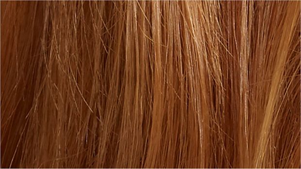 Woman straightening hair with the Dyson Corrale hair straightener