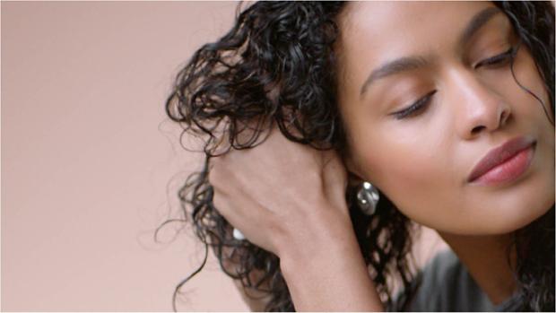 The Dyson Supersonic hair dryer with the Flyaway attachment being used on hair