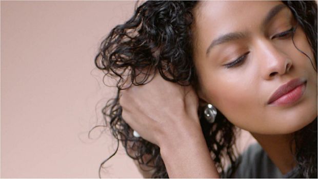 The Dyson Supersonic hair dryer with the Flyaway attachment being used on hair