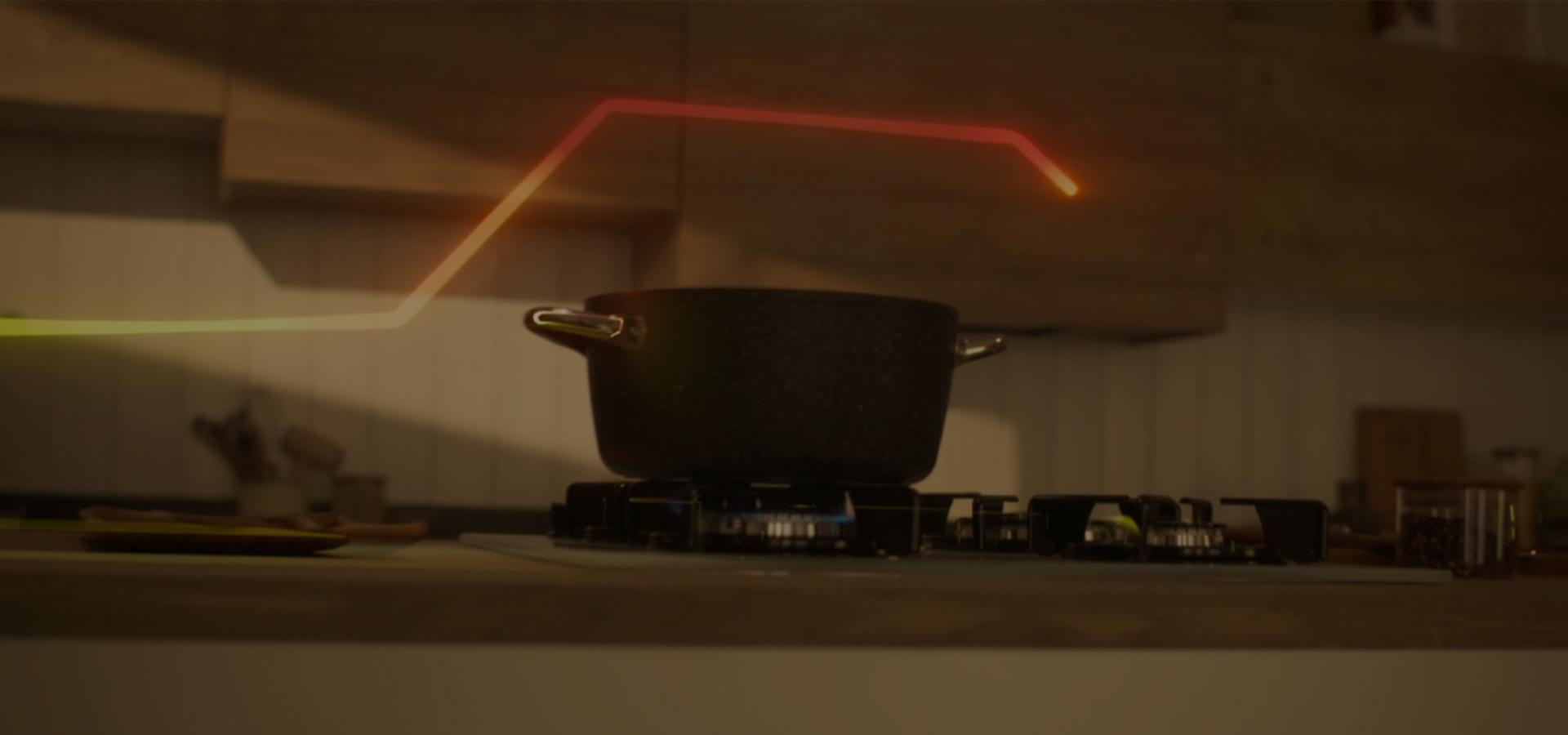 A pan on a gas hob with an air quality graphic line indicating a rise in indoor pollution.