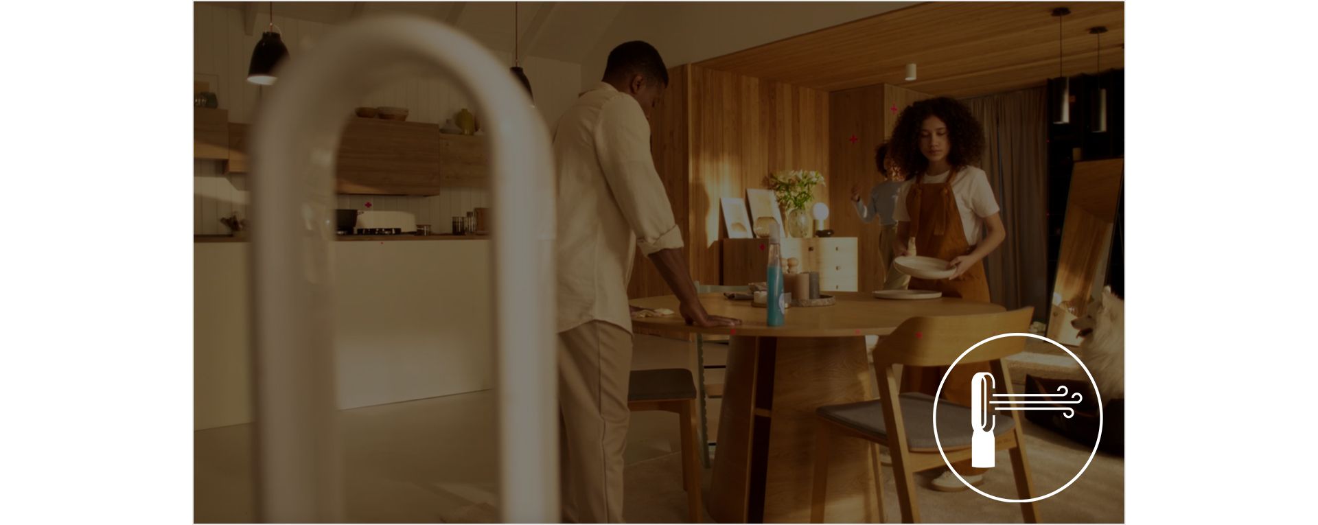 A man and woman setting the table in an open plan kitchen and dining area