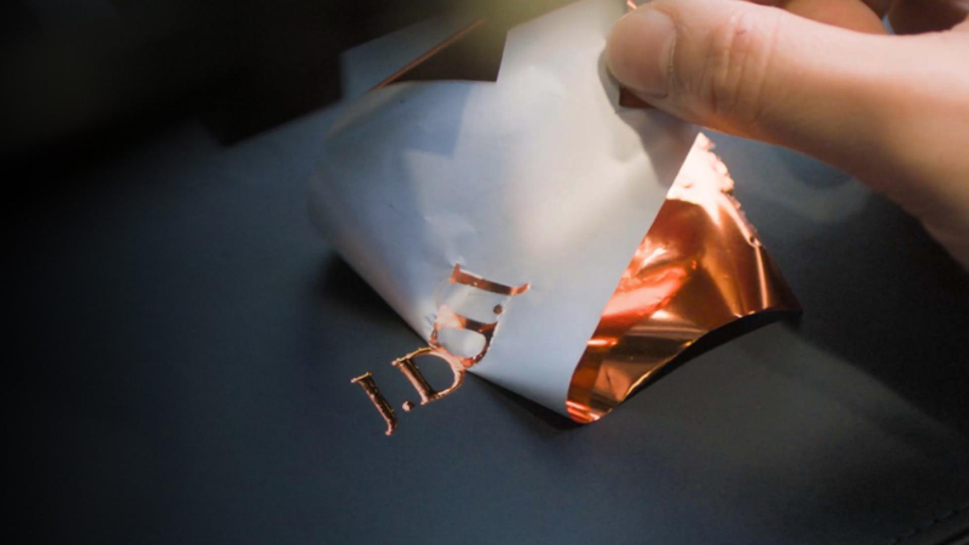 Ekspert wytłaczający inicjały na etui