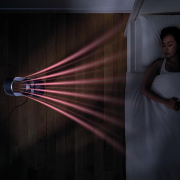 Overhead view of the Dyson Hot+Cool Jet Focus fan heater next to a bed, heating a sleeping person.