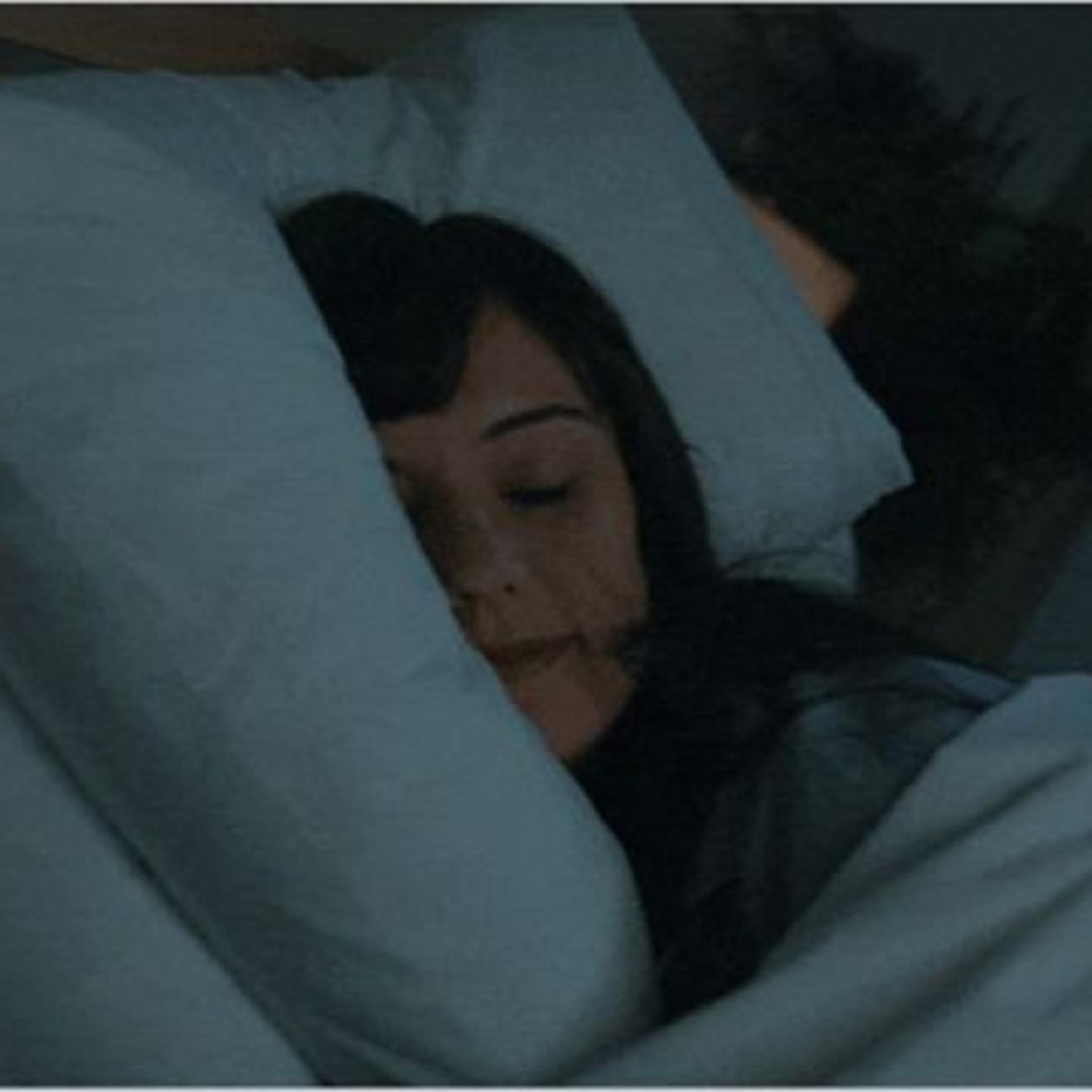 A model sleeping in bed.