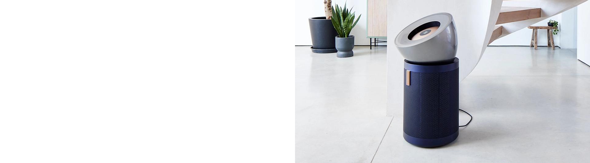 The Dyson Purifier Big+Quiet Formaldehyde and Dyson Vis Nav robot in a modern home with a spiral staircase.