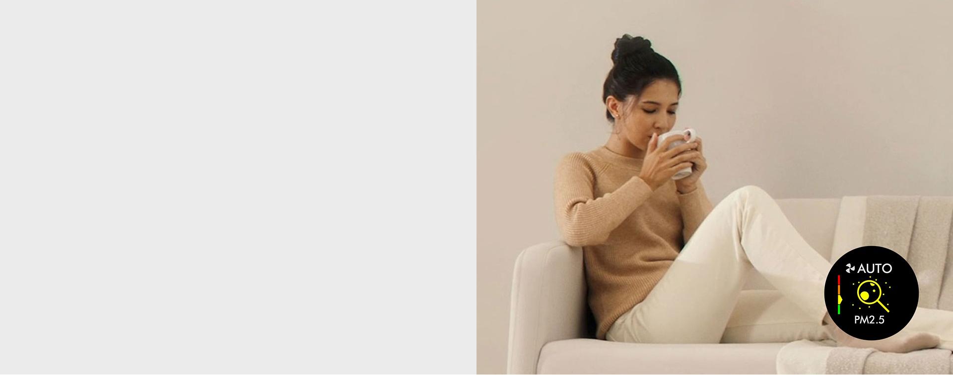 A model sitting on the sofa with a drink.