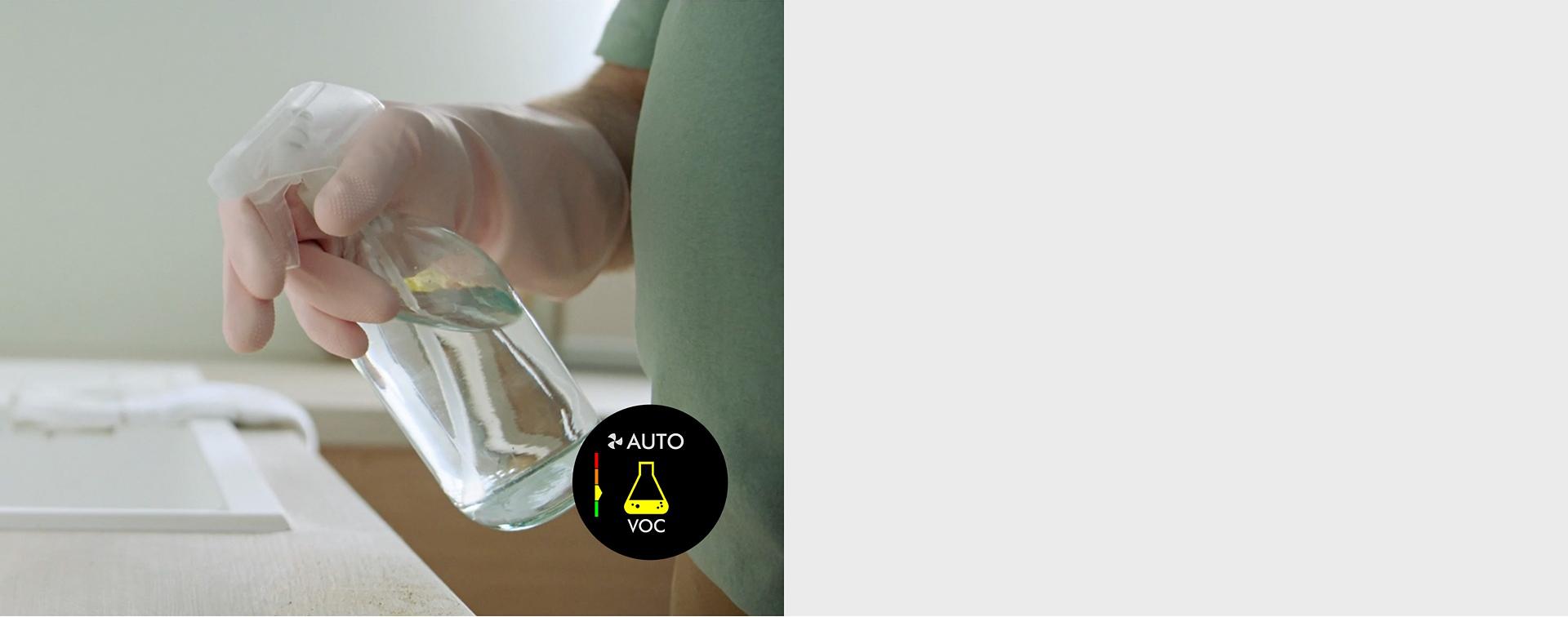 عارِضة تقوم برشّ منظف أسطح على طاولة مطبخ.