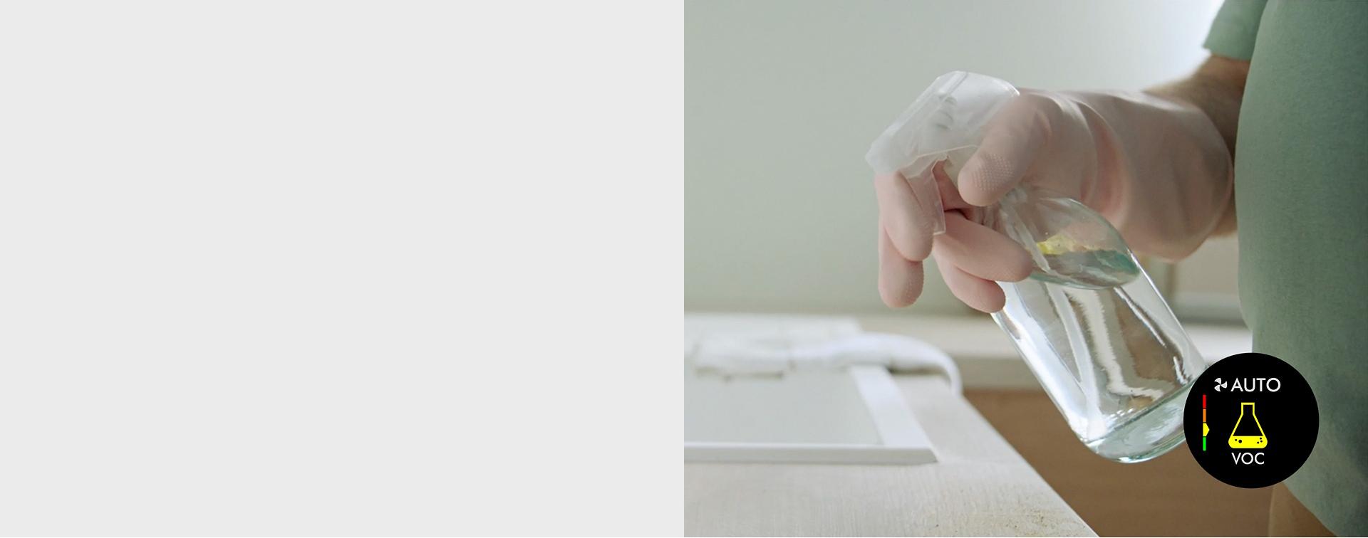 A model spraying their kitchen counter with surface cleaner.