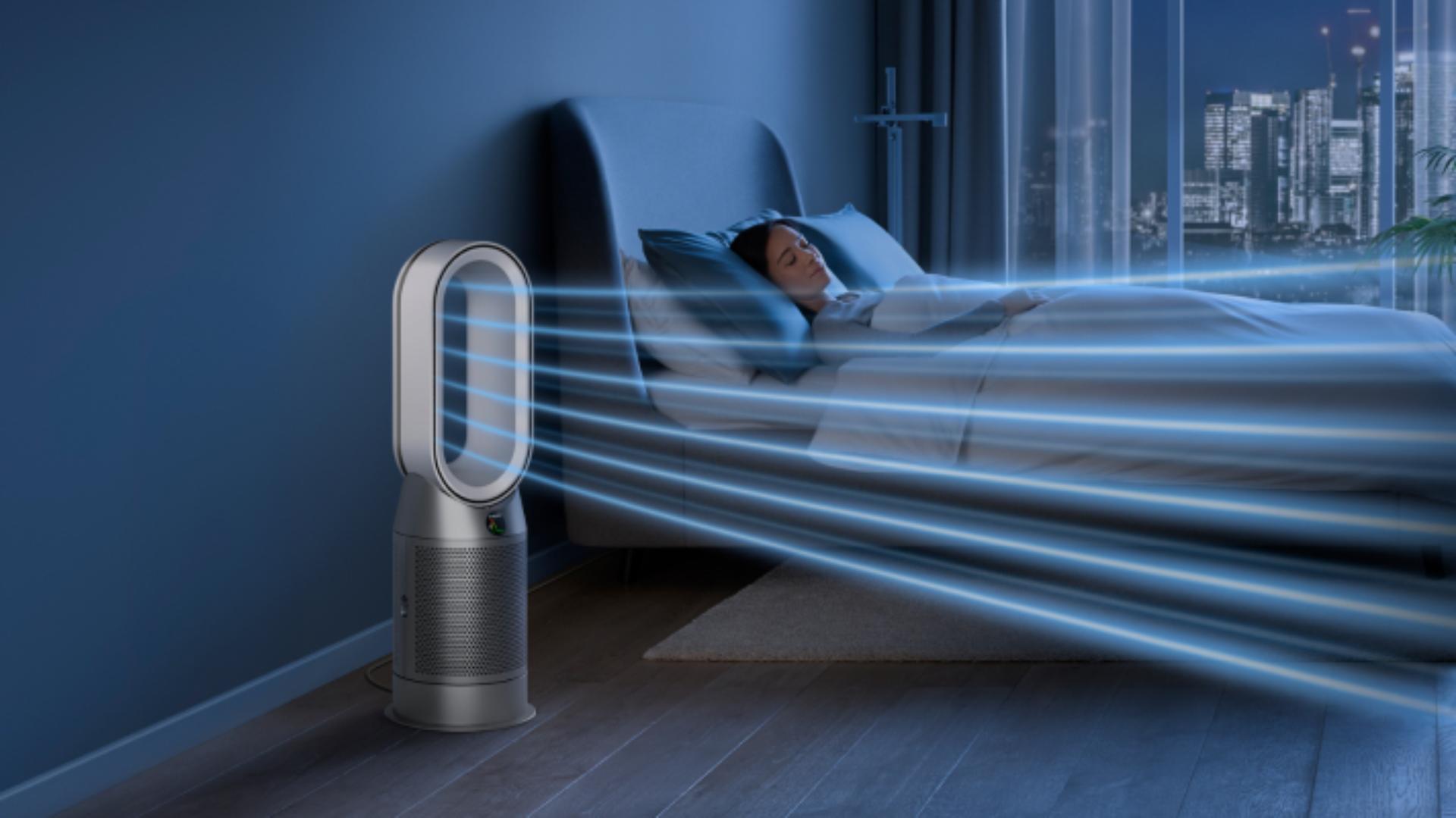 A Dyson Purifier Hot+Cool purifying fan heater purifies the air next to a sleeping person.