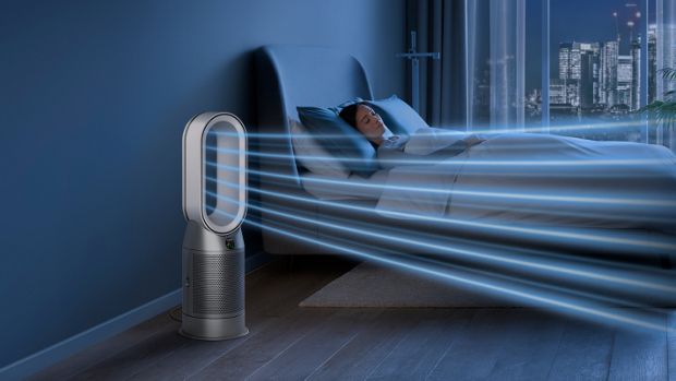 A Dyson Purifier Hot+Cool purifying fan heater purifies the air next to a sleeping person.