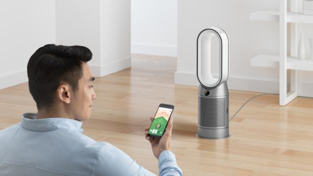 A man uses the MyDyson app to control his Dyson Purifier Hot+Cool purifying fan heater.