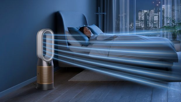 The Dyson Purifier Hot+Cool Formaldehyde in a dark bedroom at night as a woman sleeps in her bed.