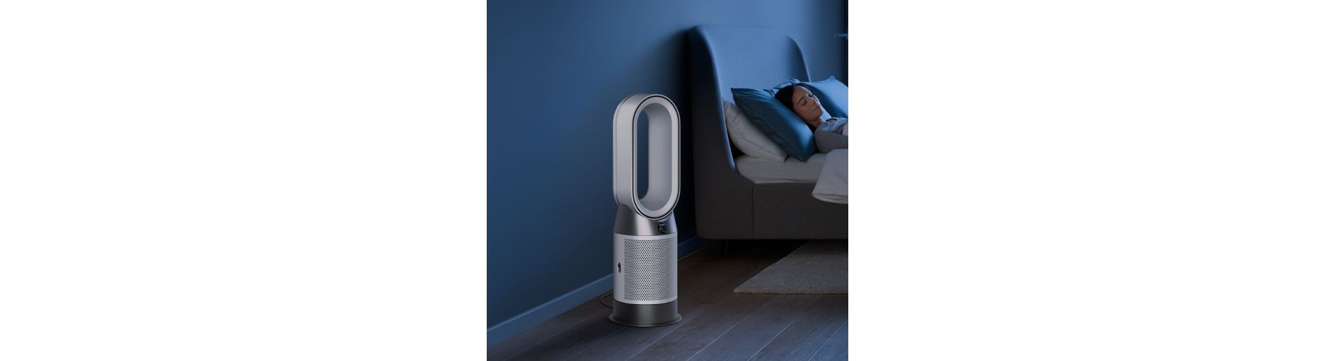 A Dyson Purifier Hot+Cool Gen1 purifying fan heater purifies the air next to a sleeping person.