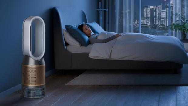 The Dyson Purifier Humidify+Cool Formaldehyde in a dark bedroom at night as a woman sleeps in her bed.