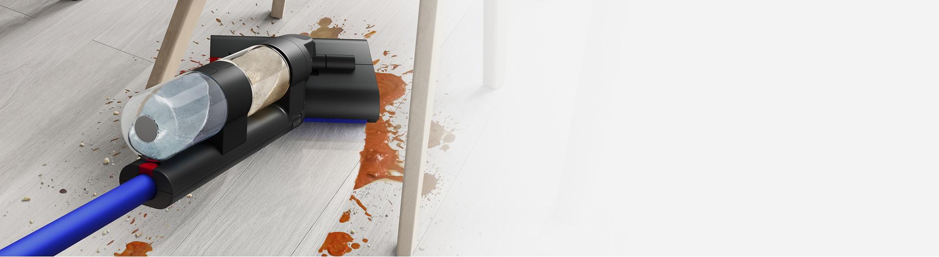 مكنسة Dyson Wash G1 للأرضيات الرطبة بينما تنظف تحت طاولة وكراسي.