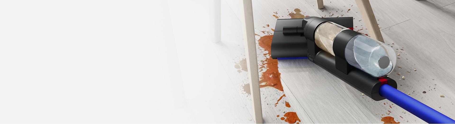 Dyson Wash G1 wet floor cleaner washing underneath a table and chairs.