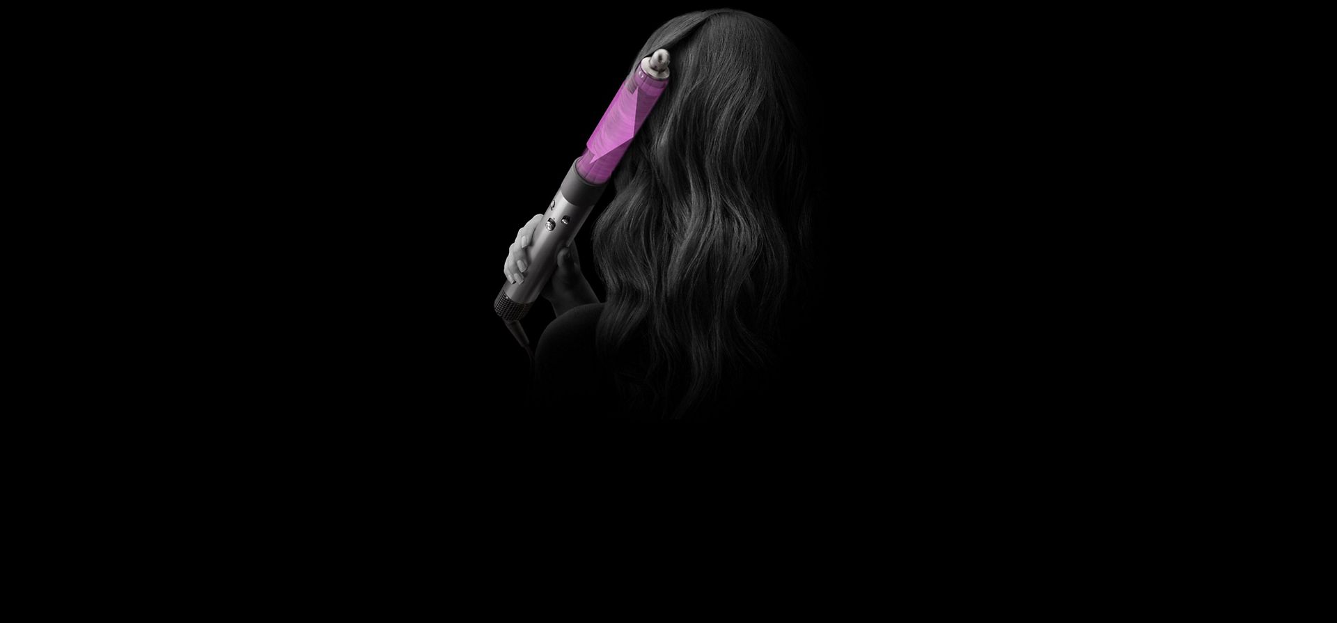 A close up of the back of a woman's head as she curls her hair with the Dyson Airwrap multi-styler and dryer