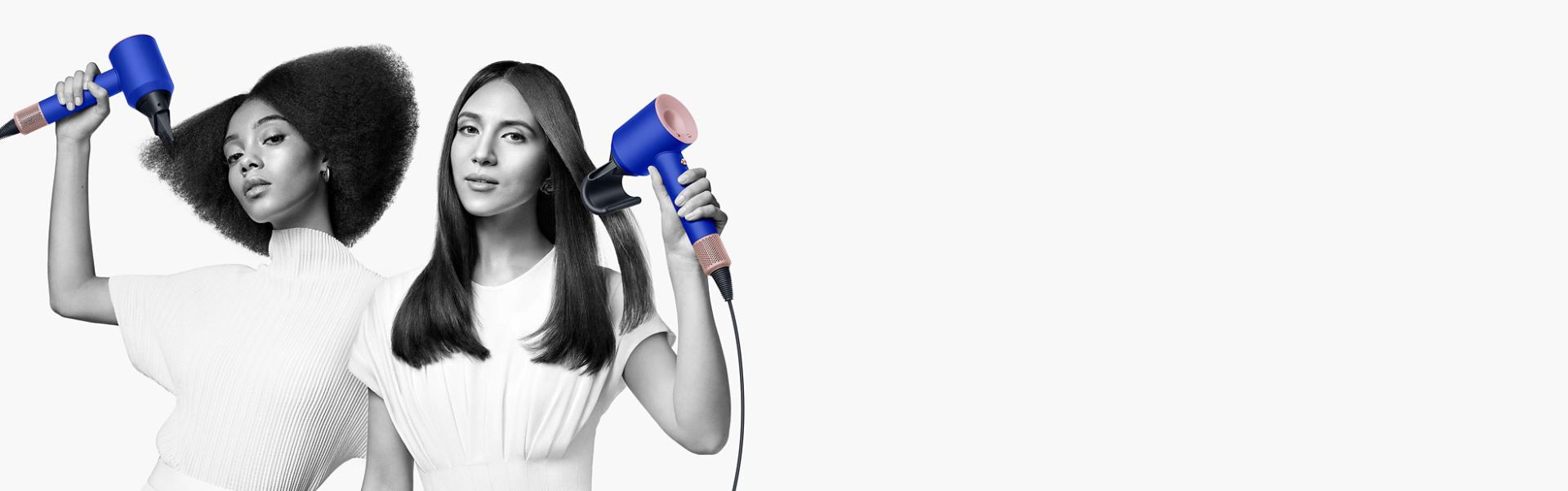 سيدتان تقومان بتجفيف شعرهما باستخدام مجفف الشعرDyson Supersonic. تَستخدم السيدة على اليسار ملحق إخفاء الشعر المتطاير لتنعيم شعرها الطويل المالس، بينما تَستخدم السيدة على اليمين ملحق مُوزِّع الهواء لتشكيل شعرها القصير الملفوف.