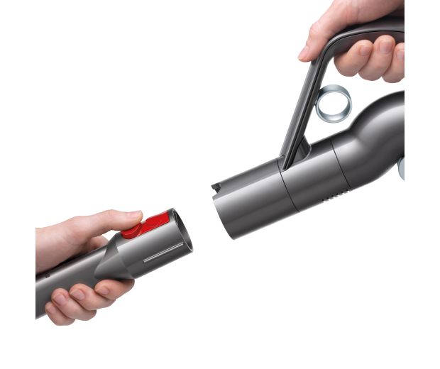 Egy személy egyetlen pattintással leveszi a porszívó kiegészítőjét.