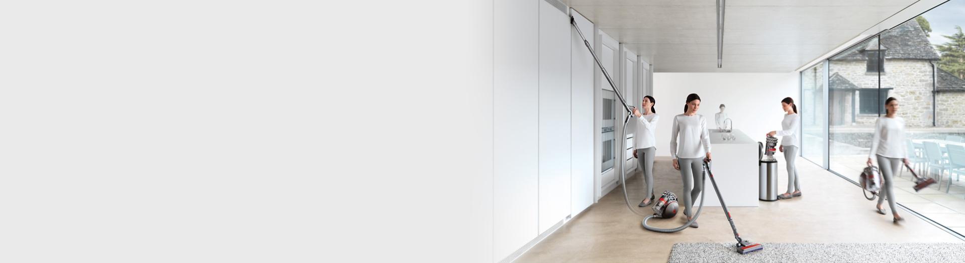 Evini temizlemek için Dyson silindir elektrikli süpürgesini kullanan bir kişi.