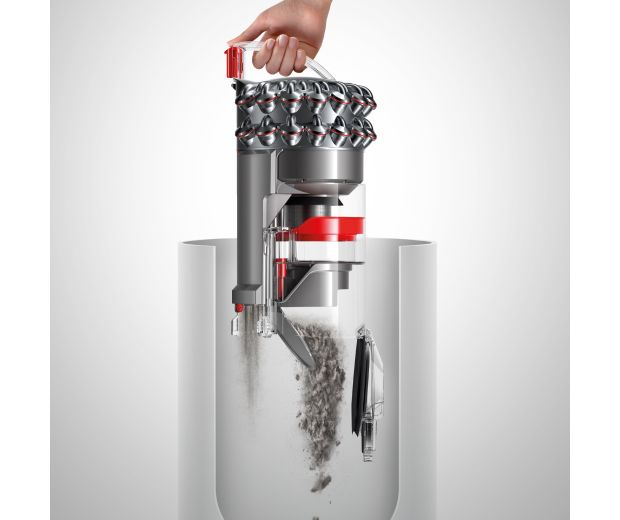 Egy személy úgy üríti ki a hagyományos porszívó portartályát, hogy nem ér hozzá a koszhoz.