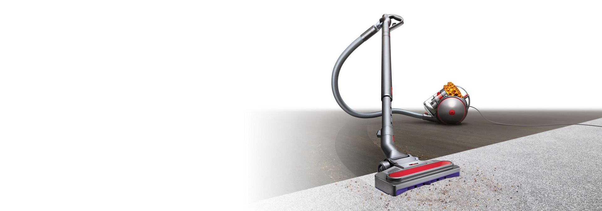 Un aspirator Dyson Cinetic Big Ball Multi Floor 2 curățând o pardoseală tare și un covor.