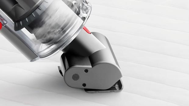 Mini motorised tool vacuuming a mattress.
