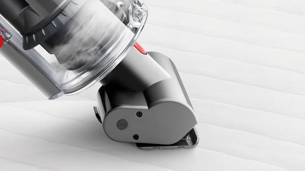 Mini motorised tool vacuuming a mattress.