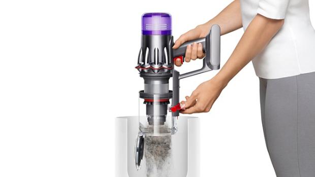 Vacuum's bin being emptied over a rubbish bin.