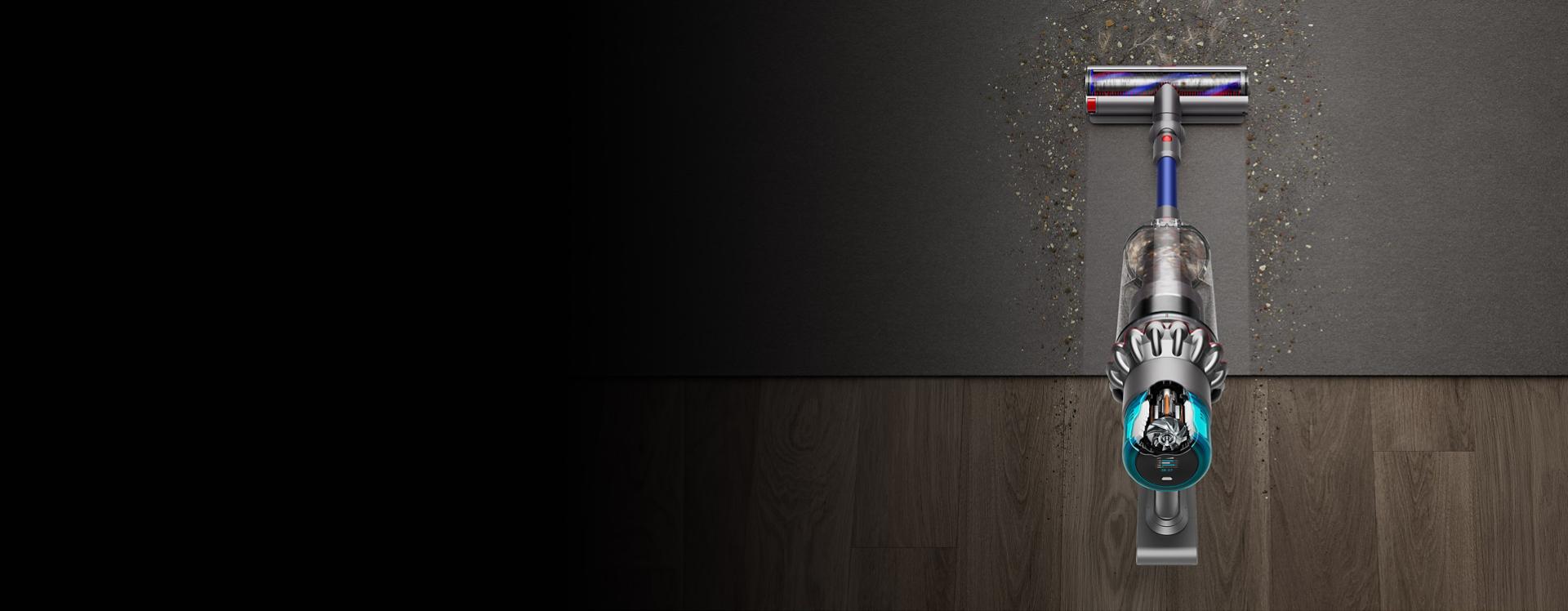 Overhead of the Dyson Gen5outsize vacuum cleaning a clear line through debris on hard floor and rugs.