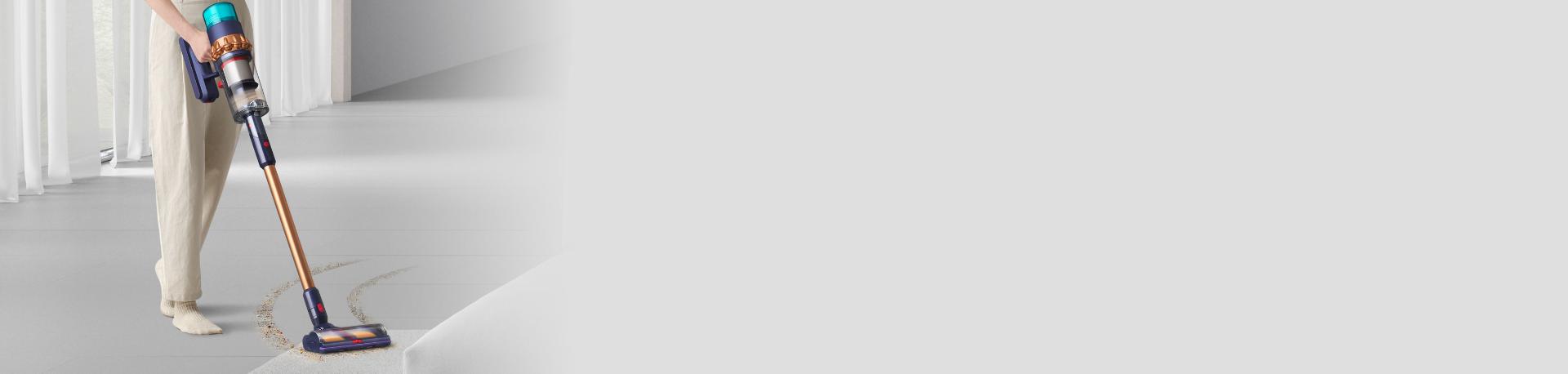 مكنسة Dyson Gen5detect بينما تُستخدَم لالتقاط المخلفات من السجاد.