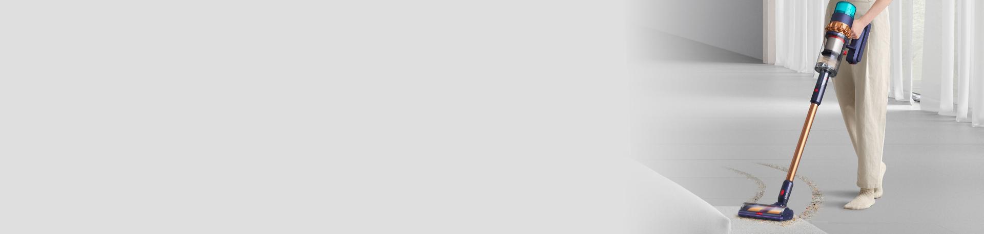 Dyson Gen5detect vacuum being used to pick up debris from carpet.