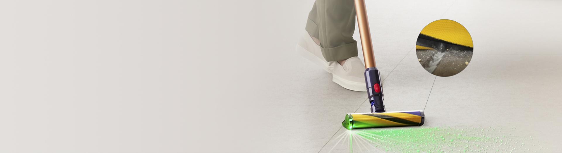 Dyson Fluffy Optic cleaner head illuminating dirt and picking up debris from the floor, with a close-up of the filaments removing dust.