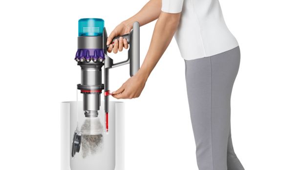 سيدة تقوم بتفريغ حاوية مكنسة Dyson Gen5detect بحركةٍ واحدةٍ.