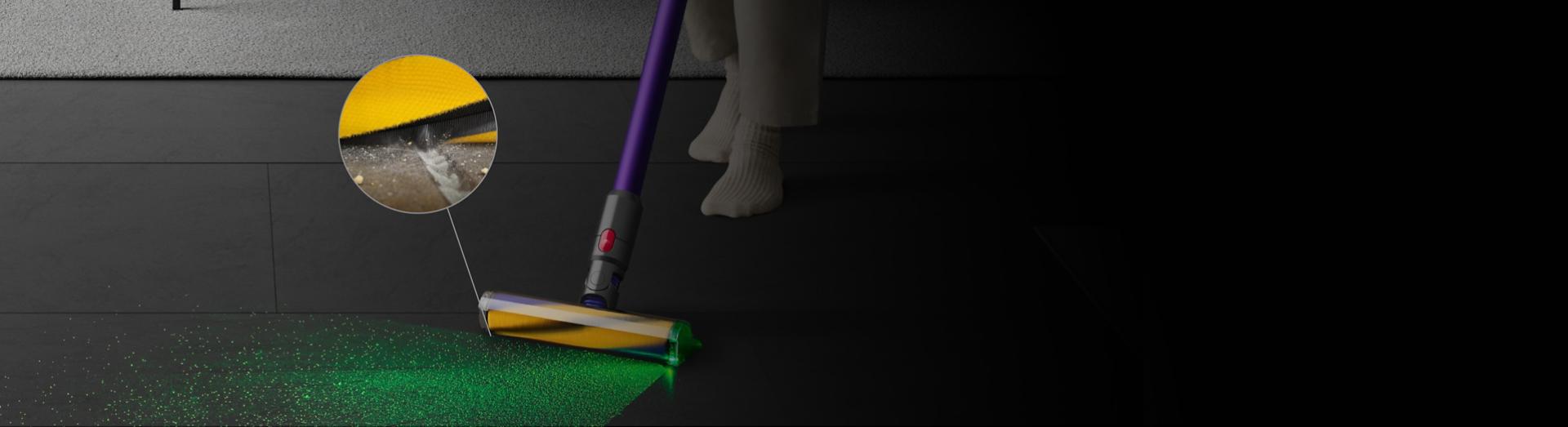 رأس تنظيف Dyson Fluffy Optic بينما يُسلِّط الضوء على الأتربة والتقاط المخلفات من الأرضية، مع صورة مُقرَّبة للخيوط وهي تُزيل الأتربة.