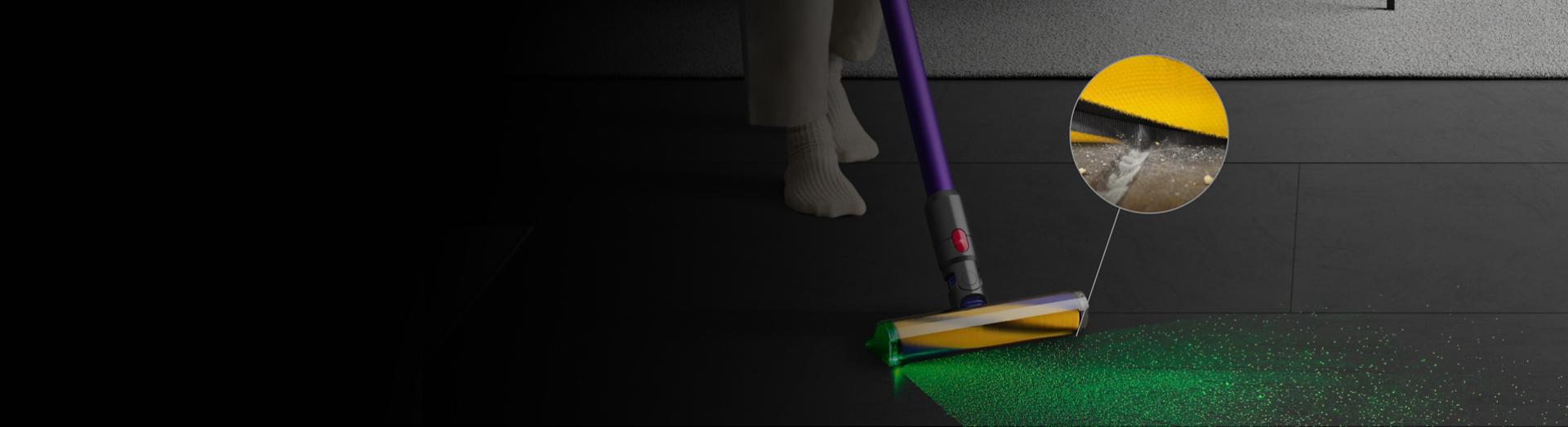 Dyson Fluffy Optic cleaner head illuminating dirt and picking up debris from the floor, with a close-up of the filaments removing dust.