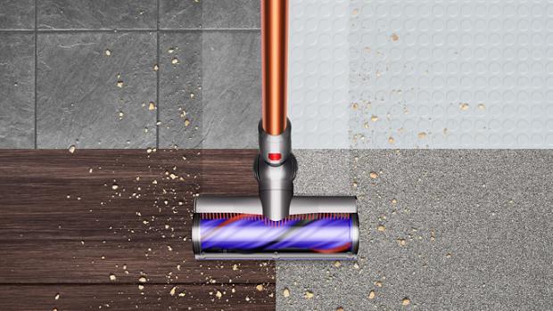 Dyson V10 picking up debris from floor.
