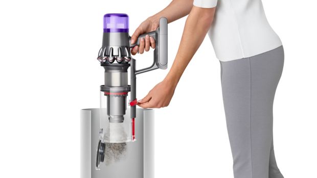 A model emptying the Dyson V11 Total Clean.