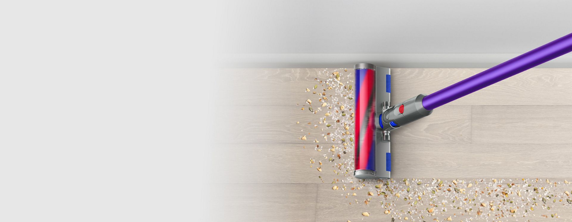 The Dyson V12 Detect Slim Absolute with Fluffy Optic cleaner head illuminating dirt on hard floor.
