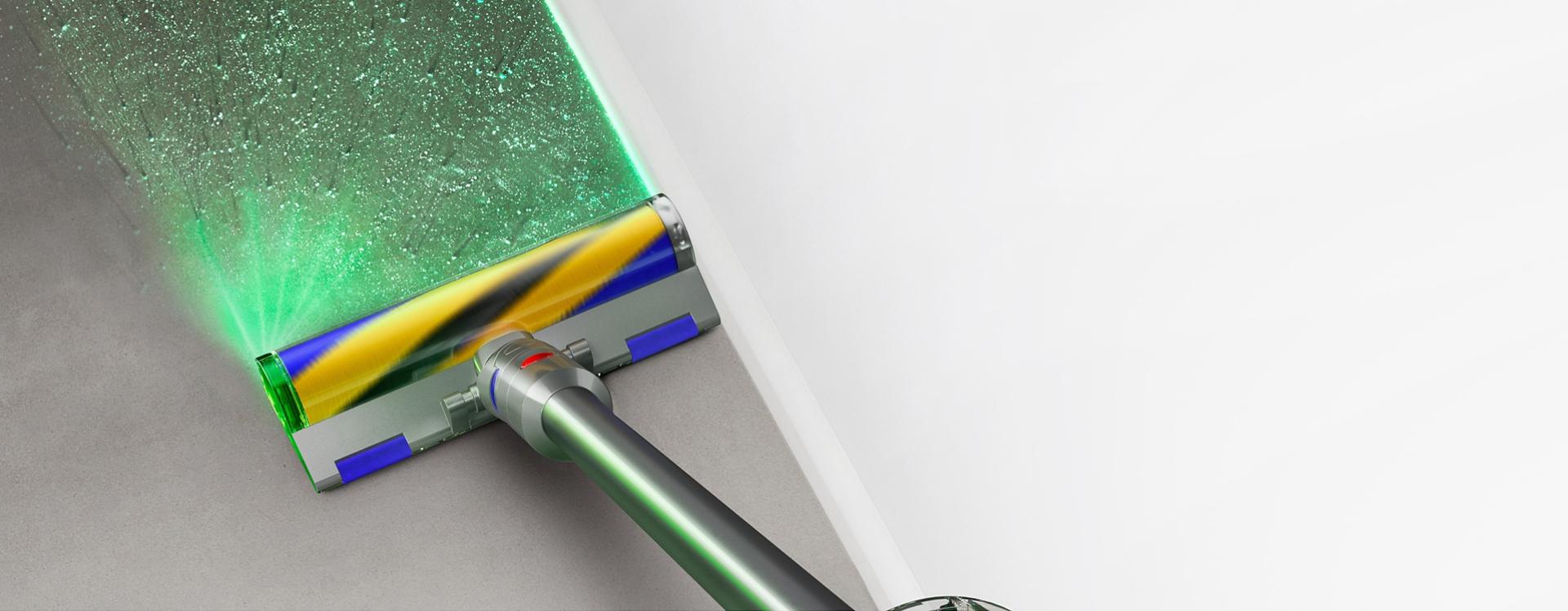 مكنسة Dyson V12 Detect Slim Absolute مع رأس التنظيف Fluffy Optic بينما تُسلط الضوء على الأتربة على الأرضيات الصلبة.