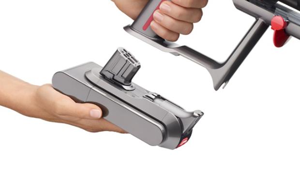 Close-up of a hand attaching a Click-in battery to the Dyson V15 Detect vacuum.