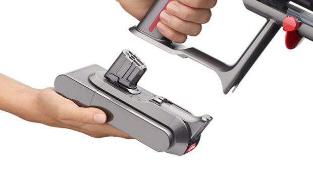 Close-up of a hand attaching a Click-in battery to the Dyson V15 Detect vacuum.