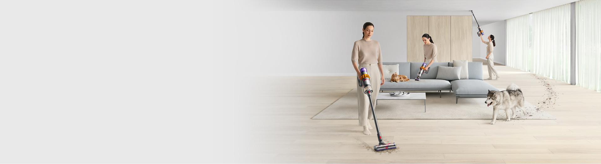 A woman cleaning different parts of a home with the Dyson V15 Detect vacuum and illuminating cleaner head.